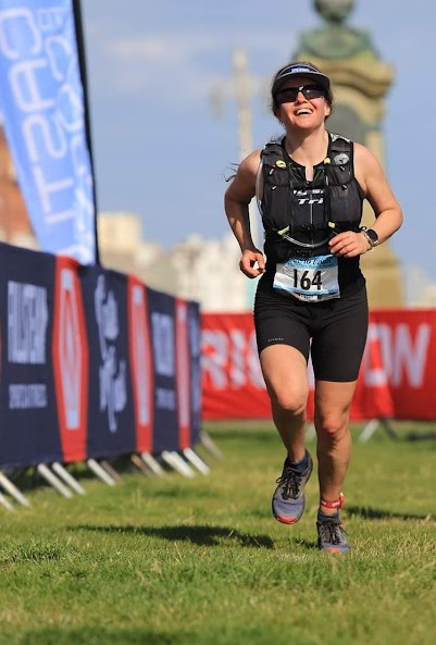 the author crossing the line of a middle distance triathlon, looking tired but triumphant